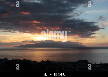 Sonnenuntergang hinter La Gomera gesehen von dem Hügel über Puerto de Santiago auf Teneriffa Kanarische Inseln Stockfoto