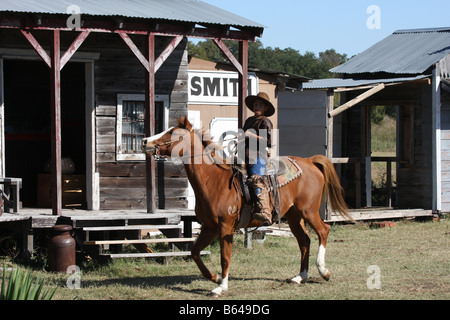 Eine afrikanische amerikanische Cowboy zu Pferd in einer alten Westernstadt Stockfoto