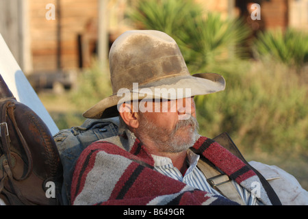 Ein Oldtimer Cowboy lehnte sich gegen seinen Pack und Sattel Stockfoto