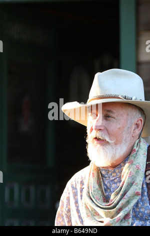 Ein Oldtimer Cowboy gelehnt ein Pferd Tie Rack Stockfoto