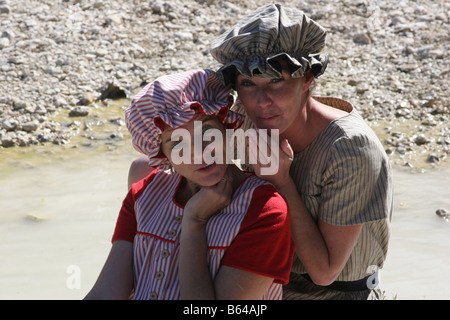 Zwei Frauen, gekleidet in den 1880er Jahren Badeanzüge Klatsch am Rande eines Baches in der Hitze des Sommers Abkühlung Stockfoto