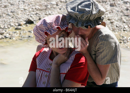 Zwei Frauen, gekleidet in den 1880er Jahren Badeanzüge Klatsch am Rande eines Baches in der Hitze des Sommers Abkühlung Stockfoto