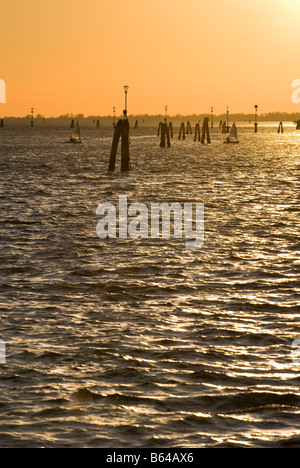 Segelboote bei Sonnenuntergang von Uferpromenade am Gardini Pubblici, Lido di Venzia im Hintergrund, Sestiere Castello Venedig Italien Stockfoto