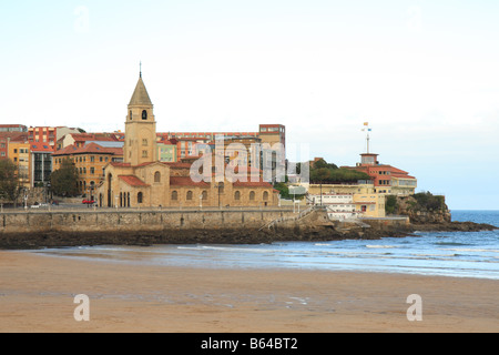 Blick auf den Strand von San Lorenzo mit der Kirche von San Pedro in Gijon Spanien. Stockfoto