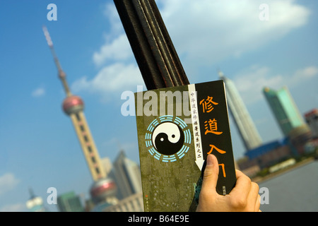 China, Shanghai, Gebiet namens: The Bund, entlang des Huangpo-Flusses. Skyline von Pudong. Buchen Sie auf Taoismus mit Ying - Yang-Zeichen. Stockfoto