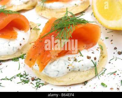 Häppchen von Wild Alaskan Coho Räucherlachs auf Blinis mit Sauerrahm und Dill. Stockfoto