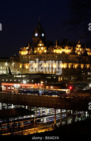 Nachtansicht der Waverley Bahnhof mit dem Balmoral Hotel in Princess Street Edinburgh im Hintergrund Stockfoto