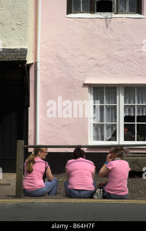 Drei Frauen in rosa saß an der Straße identisch gekleidet Stockfoto