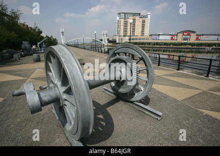 Stadt von Salford, England. Dock-Fracht-Skulptur in Salford Quays mit Lowry Outlet Mall und Kino rot im Hintergrund. Stockfoto