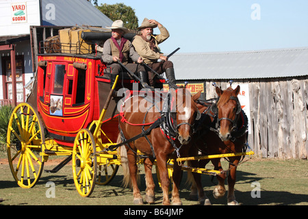 Zwei Cowboys, die einer alten Westernstadt Butterfield Overland Stage Coach durchfahren Stockfoto