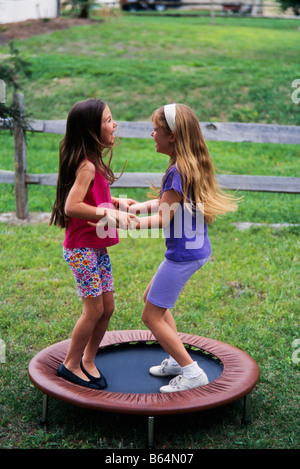 Zwei junge Mädchen auf kleinen Trampolin springen lachend, Havimng Spaß, Miami Stockfoto