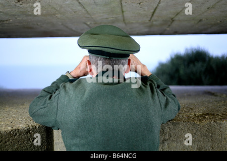 Ein Schauspieler verkleidet als ein deutscher Offizier, Blick über den Ärmelkanal von einem deutschen D-Day-Bunker in der Normandie Frankreich Stockfoto