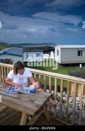 Frau entspannen auf der Veranda einen Wohnwagen im Woolacombe Bay Holiday Park Stockfoto