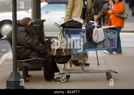 Obdachloser auf Bank auf 5th Ave NYC USA schlafen Stockfoto