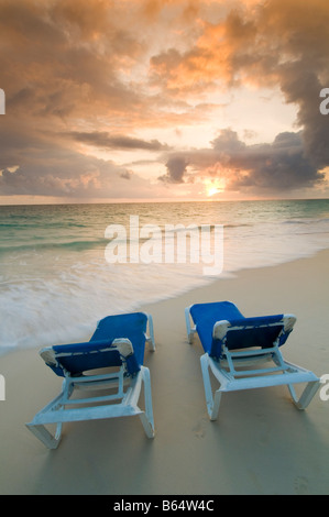 Karibik Dominikanische Republik paar Sonnenliegen am Strand bei Sonnenaufgang vor Resort all inclusive Stockfoto