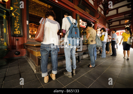 Gebete am Main Hall der Senso-Ji-Tempel (aka Asakusa-Tempel). Asakusa. Taito Bezirk. Tokyo. Japan. Stockfoto