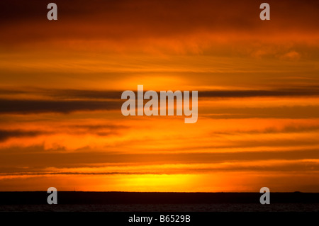 Sommersonnenuntergang spiegelte sich glühend in Wolken über einem meeisfreien Beaufort Sea 1002 Gebiet des Arctic National Wildlife Refuge, North Slope, Alaska Stockfoto