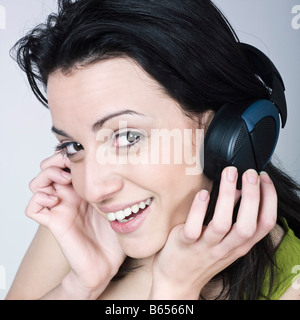 Porträt einer jungen Frau hören Musik auf isolierte Hintergrund Stockfoto