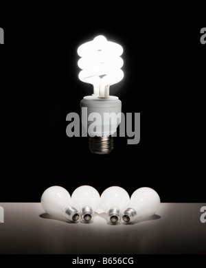 Eine beleuchtete kompakte Leuchtstofflampen Lampe schwebt über mehrere Glühlampen, die nach oben neidvoll blicken Stockfoto