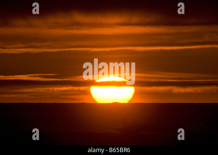 Sommer Sonnenuntergang spiegelt sich glühend in Wolken über Beaufort Meer eisfrei Stockfoto