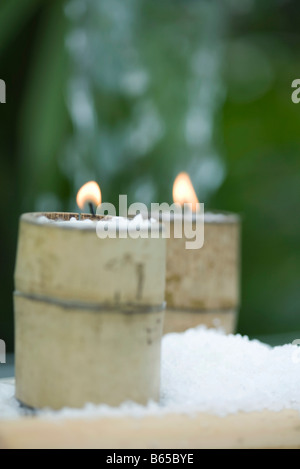 Kerzen in Bambus Haltern umgeben von Schnee Stockfoto