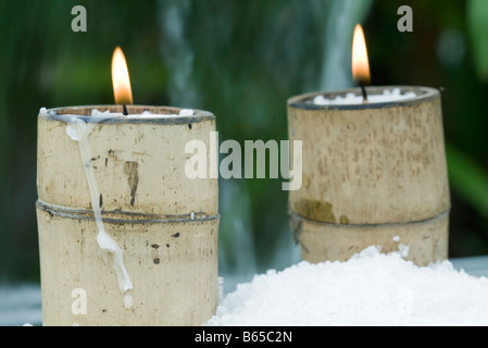 Brennende Kerzen in Bambus Haltern umgeben von Schnee Stockfoto