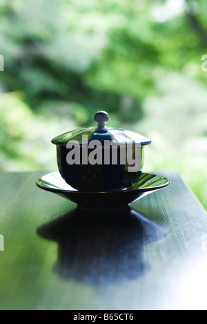 Überdachte Teetasse und Untertasse auf Tisch Stockfoto