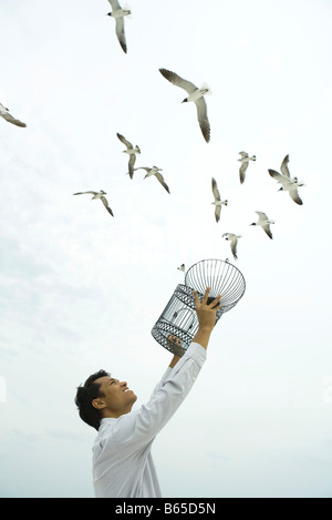 Releasing Vogel im freien Mann, Käfig in der hand zu öffnen Stockfoto