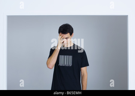 Mann trägt t-Shirt mit Barcode gedruckt für Gesicht mit hand Stockfoto