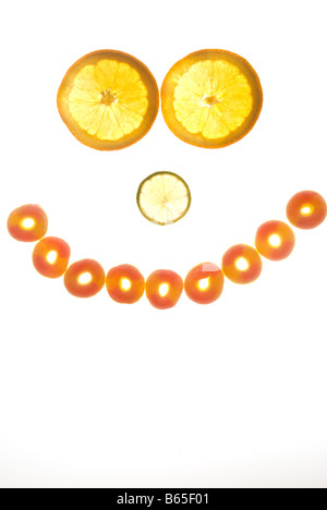 Smily Gesicht gemacht aus Orangen und Süßigkeiten Stockfoto