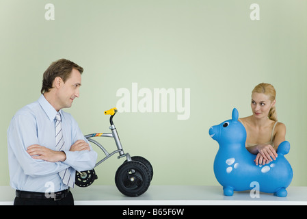 Paar Spielzeug bereit, einander betrachtend, gefaltet Mannes Arme Stockfoto