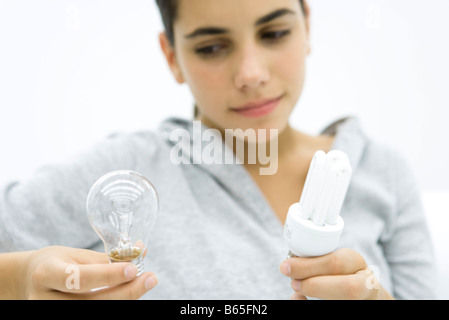 Vergleich von konventionellen Glühbirne und Energie effiziente Glühbirne Teengirl Stockfoto