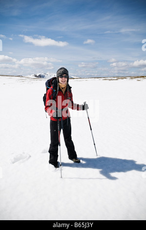 Weibliche Wanderer steht auf Schnee nahe Gipfel des Cairn man im Cairngorms, Schottland Stockfoto