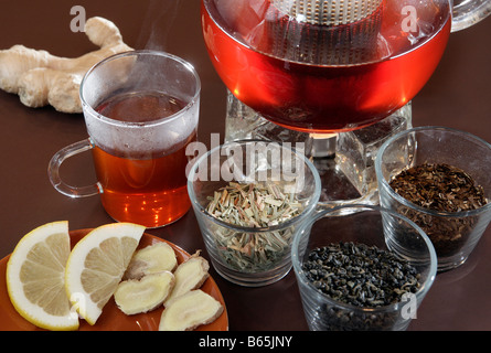 Tee-Stillleben mit Rooibos Tee & Teetasse, Teekanne, Zitrone und Ingwer Stockfoto