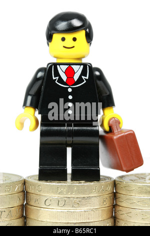 LEGO Geschäftsmann stehend auf Haufen Geld - Erfolg Geschäftskonzept Stockfoto