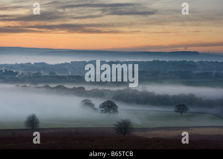 Die Aussicht vom Baildon Moor bei Sonnenuntergang, als Nebel füllt die Aire Valley am Eldwick, in der Nähe von Bradford, West Yorkshire Stockfoto