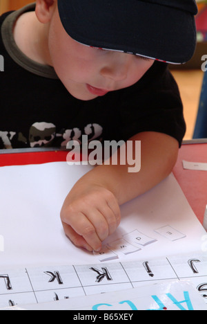 Kleiner Junge lernen, das Alphabet im Kindergarten zu nutzen Stockfoto