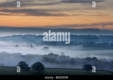 Die Aussicht vom Baildon Moor bei Sonnenuntergang, als Nebel füllt die Aire Valley am Eldwick, in der Nähe von Bradford, West Yorkshire Stockfoto