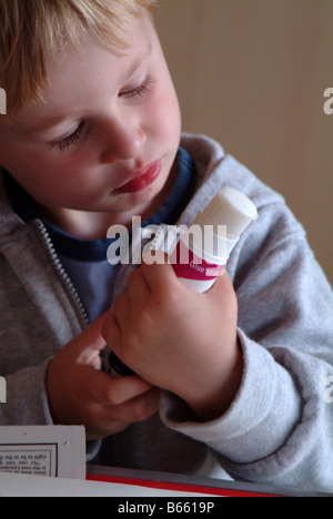 Kleiner Junge betrachtet man einen Klebestift Stockfoto