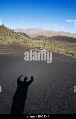 Der Schatten des jubelnden Wanderer gegen die schwarzen Bimsstein von Lava links fließt vor tausenden von Jahren im Krater des Mondes National Monument, Idaho. Stockfoto