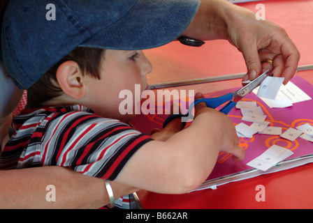 Kind Buchstaben des Alphabets mit einer Schere ausschneiden Stockfoto
