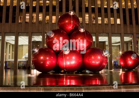 Große rote Kugeln als Schmuck für den Weihnachtsbaum als eine Kunstausstellung auf der 6th Avenue in New York City Stockfoto