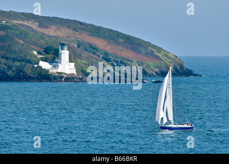 Eine Yacht Segeln vorbei an St Anthony Leuchtturm gegenüber Pendennis Punkt in der Nähe von Falmouth, Cornwall. Stockfoto