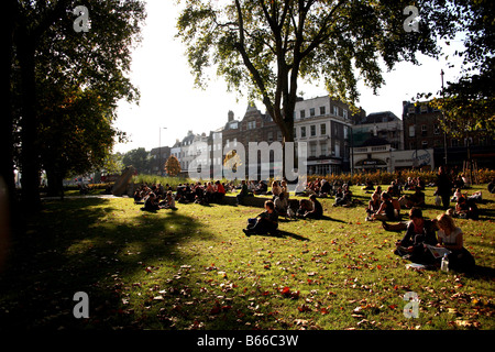 Sonntag Publikum genießt die späte Nachmittagssonne auf Islington Green, London Stockfoto