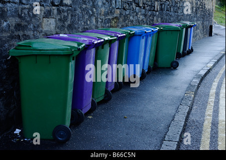 Linie der bunte recycling-Behälter aufgereiht vor einer Steinmauer Stockfoto