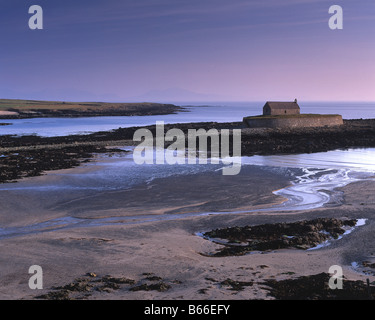 Sonnenuntergang bei Aberffraw Anglesey mit St Cwyfan Kirche auf der winzigen Gezeiten-Insel Cribinau Stockfoto