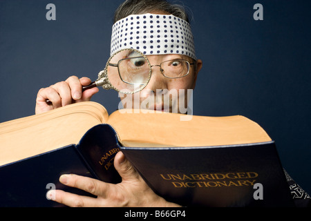 Ältere Japaner tragen traditionelle Kleidung verwendet Lupe, um ein Wörterbuch zu lesen Stockfoto