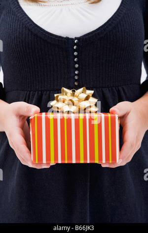 Girl holding present, mid section Stockfoto