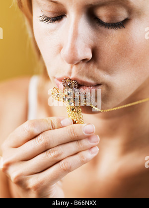 Mid-Adult Frau küssen Kreuz Stockfoto