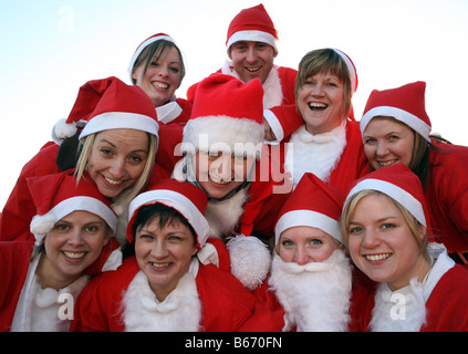 Line-up der Weihnachtsmänner tragen rote Weihnachtsmann-Kostüme, die Teilnahme an jährlichen Santa laufen entlang des Strandes in Aberdeen, Schottland, Vereinigtes Königreich Stockfoto